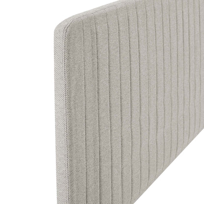 Oatmeal fabric headboard with vertical channel tufting on a rounded upholstered panel