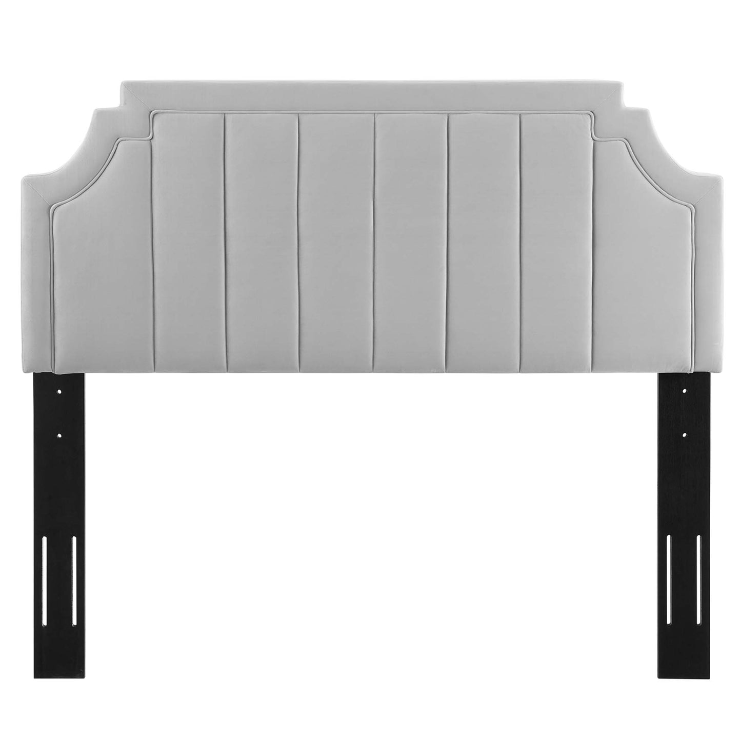 Light gray upholstered headboard with vertical channel tufting, curved end shapes, mounted on black metal legs.