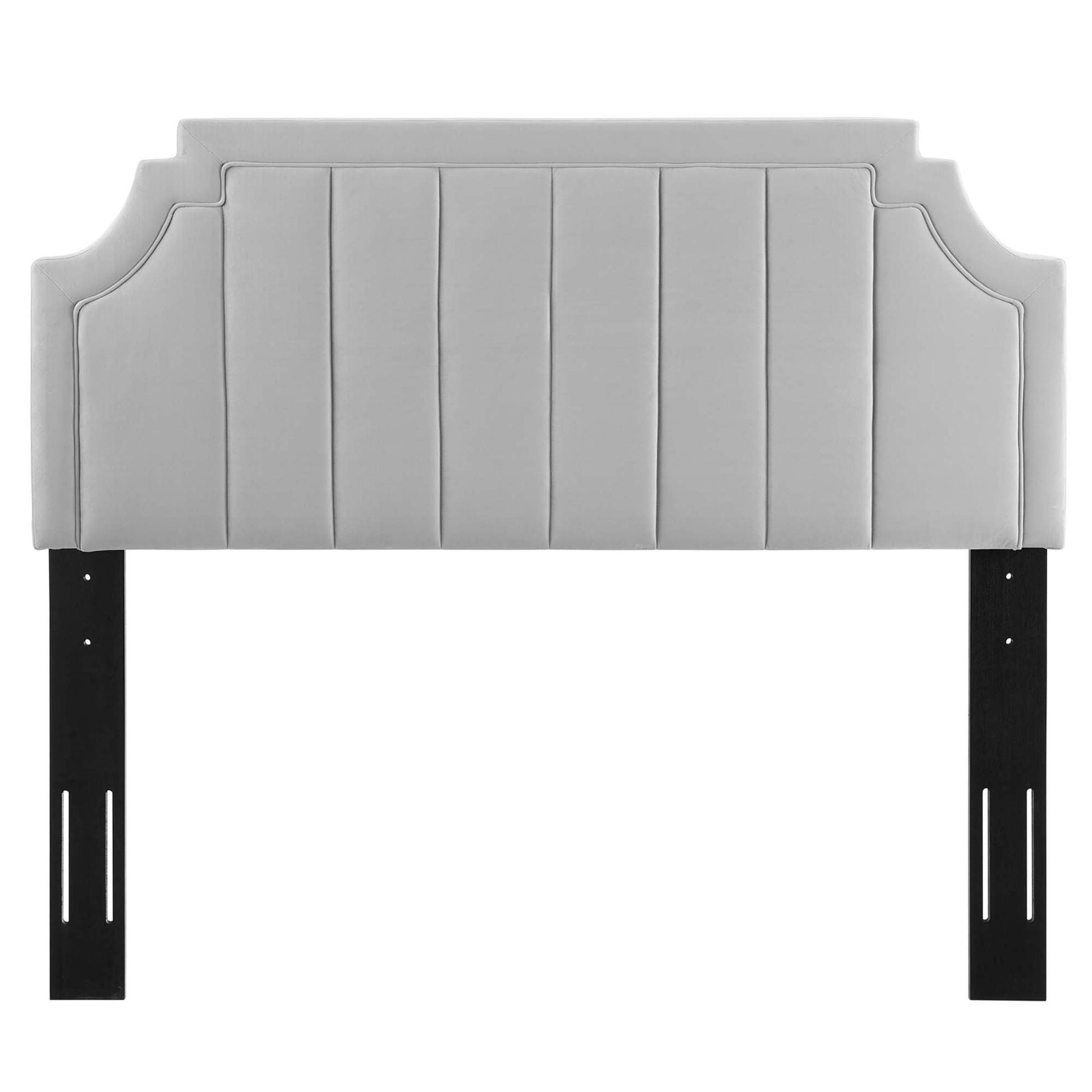 Light gray upholstered headboard with vertical channel tufting, curved end shapes, mounted on black metal legs.