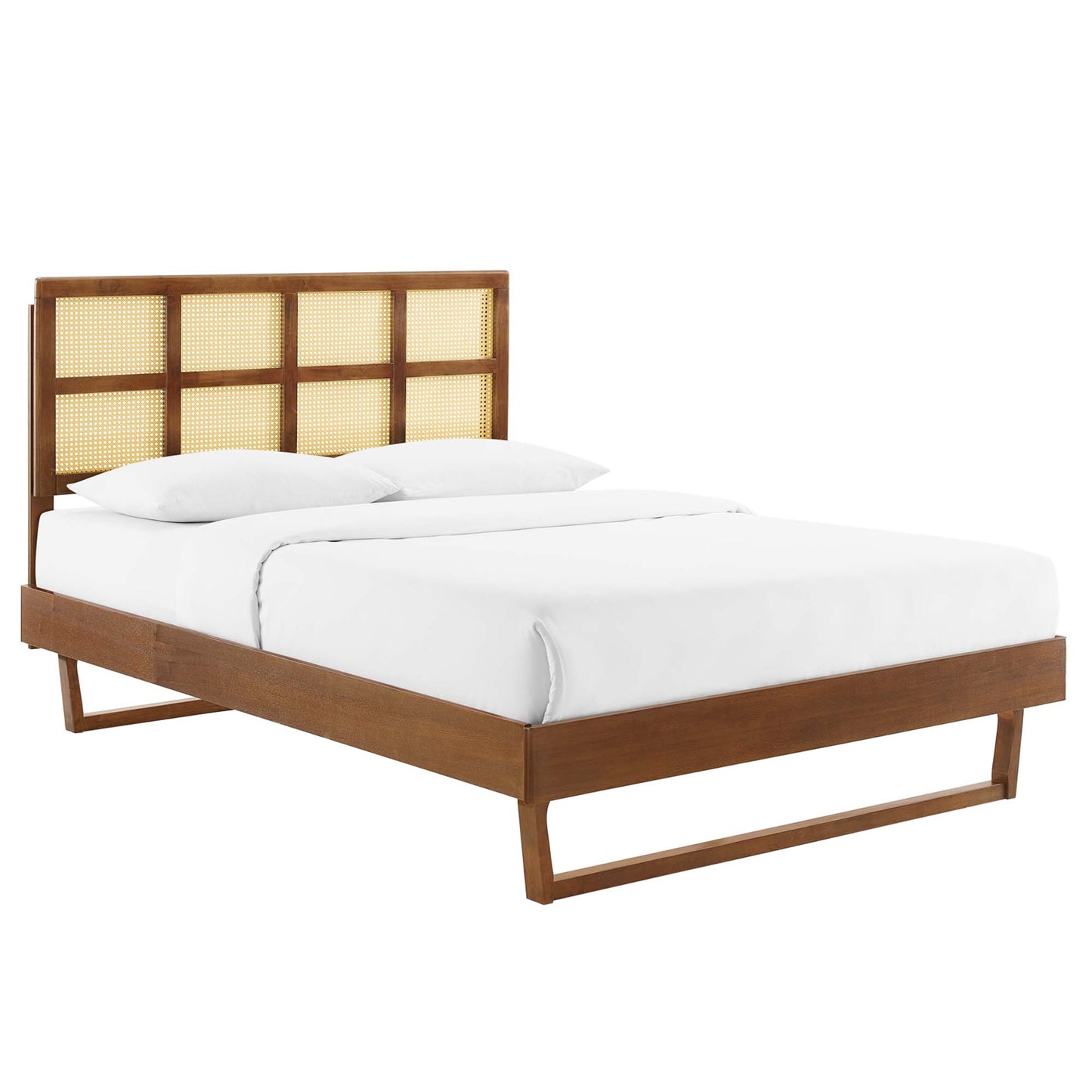 Walnut king platform bed with woven cane panel headboard and angular legs, white bedding.