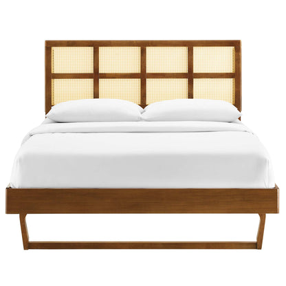 Walnut platform bed with four-panel caned headboard, low footboard, angled legs, and white bedding.
