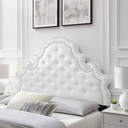 White tufted fabric headboard with scalloped Rococo silhouette and silver nailhead trim, glam bedroom centerpiece.