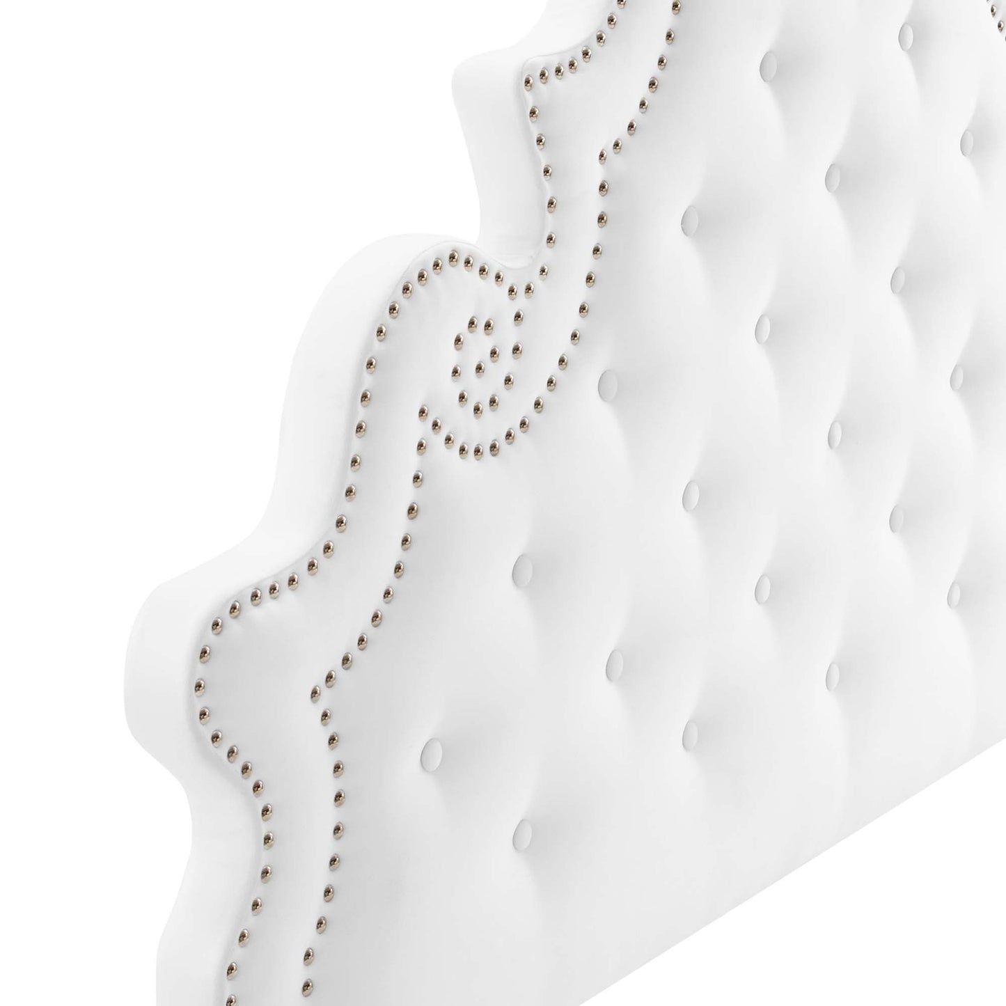 White tufted upholstered headboard with silver nailhead trim and scrolling border.