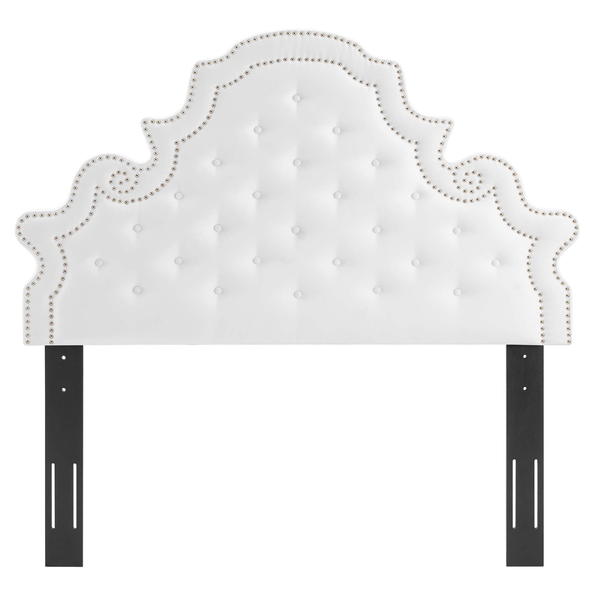 White tufted headboard with ornate curved silhouette and nailhead trim, mounted to black metal posts.