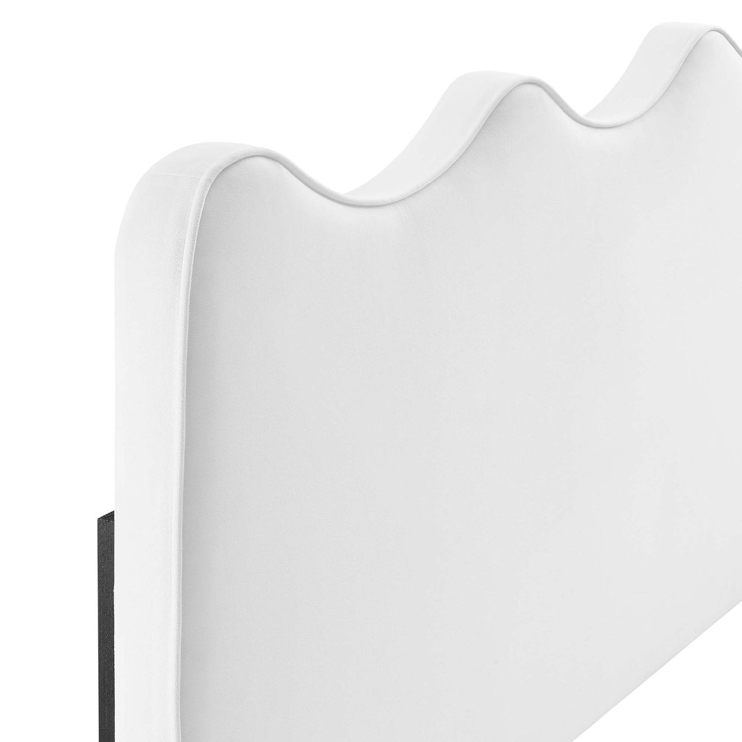 White fabric-covered headboard with a wave-shaped, scalloped top for modern bedroom decor.