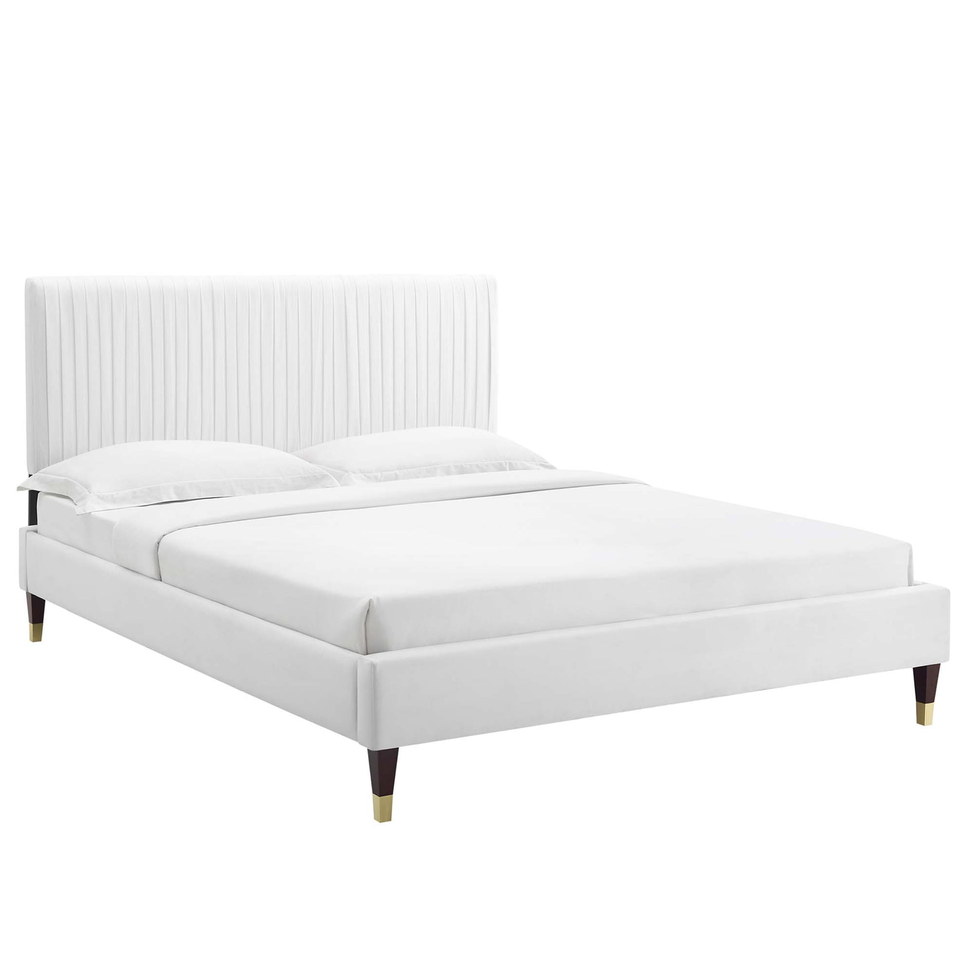 White upholstered platform bed with tall vertical channel-tufted headboard, low base & tapered wooden legs.