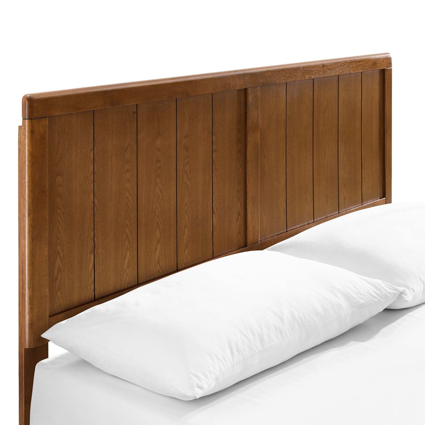 Walnut wood headboard with vertical slats and an angular bed frame, on a bed with white pillows.