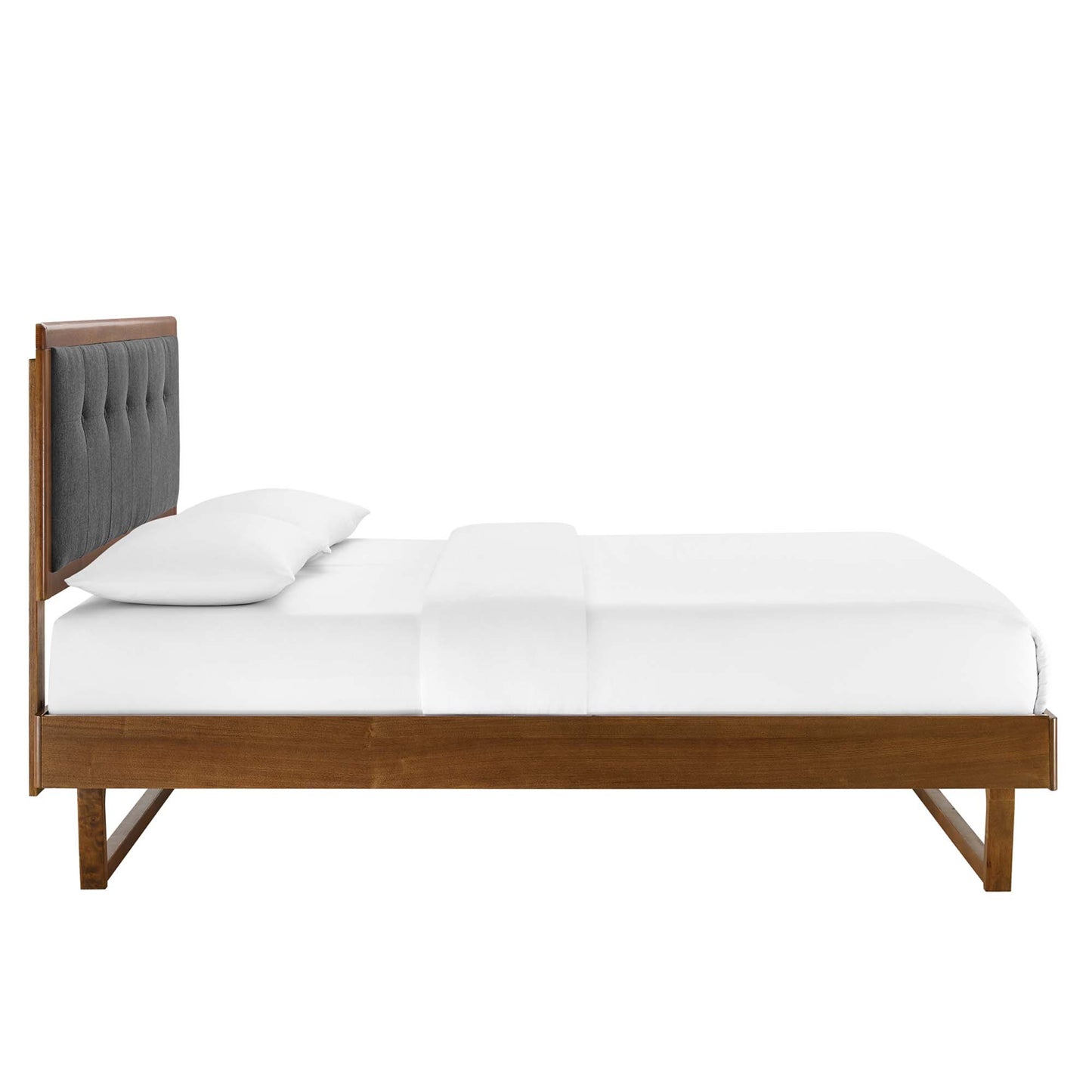 Walnut platform bed with dark gray tufted headboard and white linens.