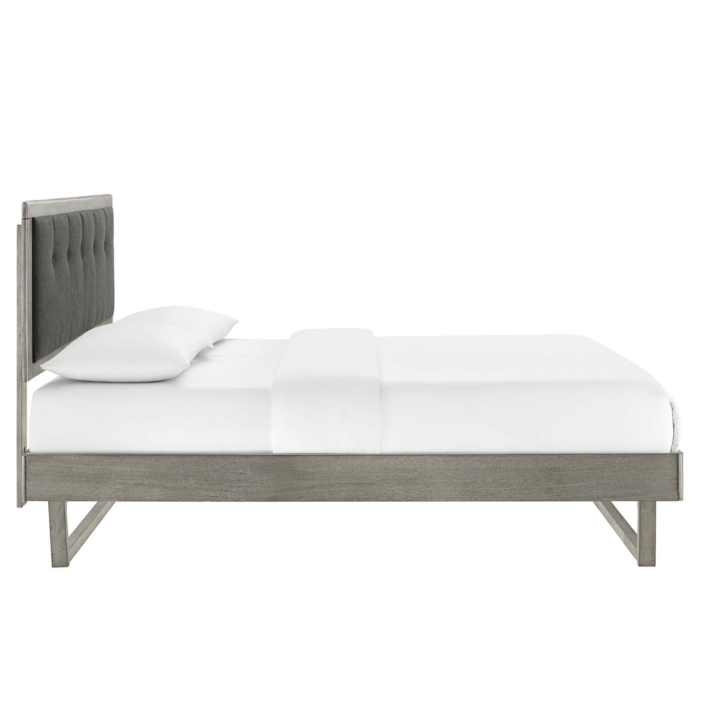 Platform bed with weathered gray wood frame and angular design, white bedding.