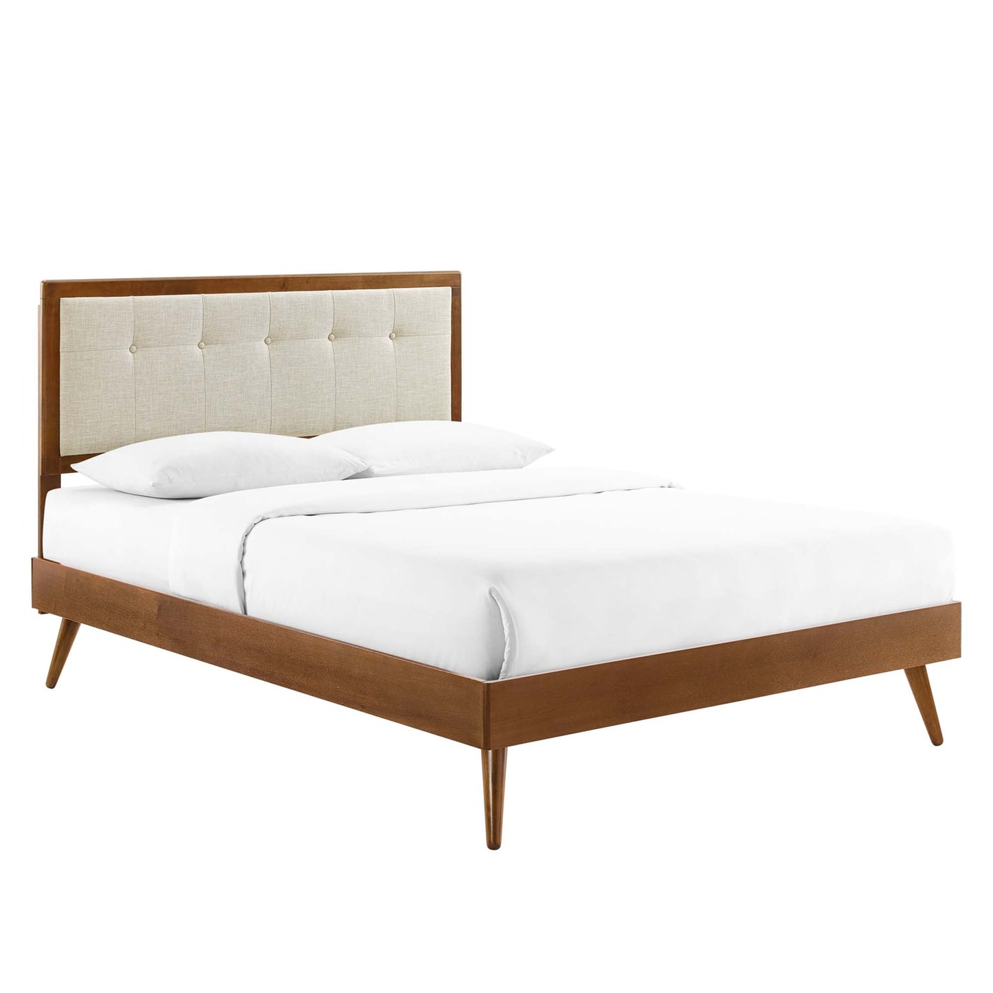Mid-century walnut bed with tufted beige fabric headboard, tapered legs, and white linens.
