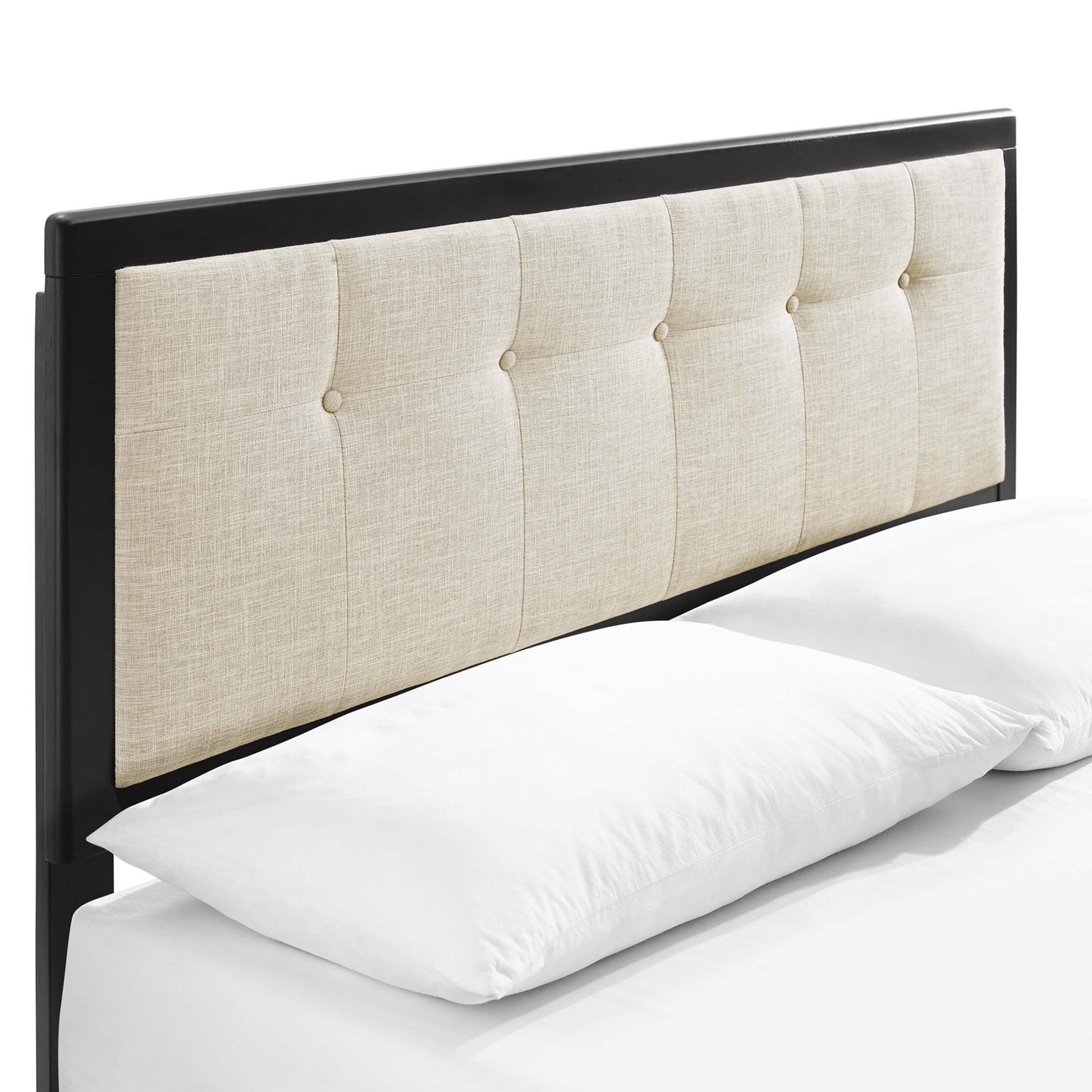 Brown wood king platform bed with splayed legs and a beige tufted headboard with button-tufted panels on white bedding.