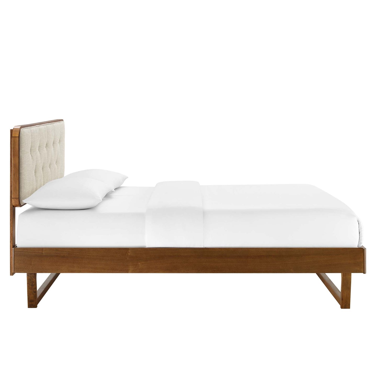 Walnut wood twin platform bed with angular frame and beige tufted upholstered headboard, white bedding.