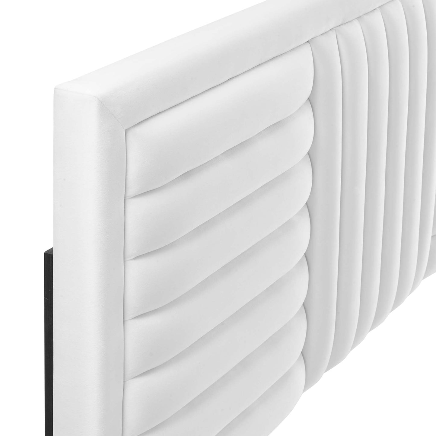 White upholstered headboard with channel tufting.