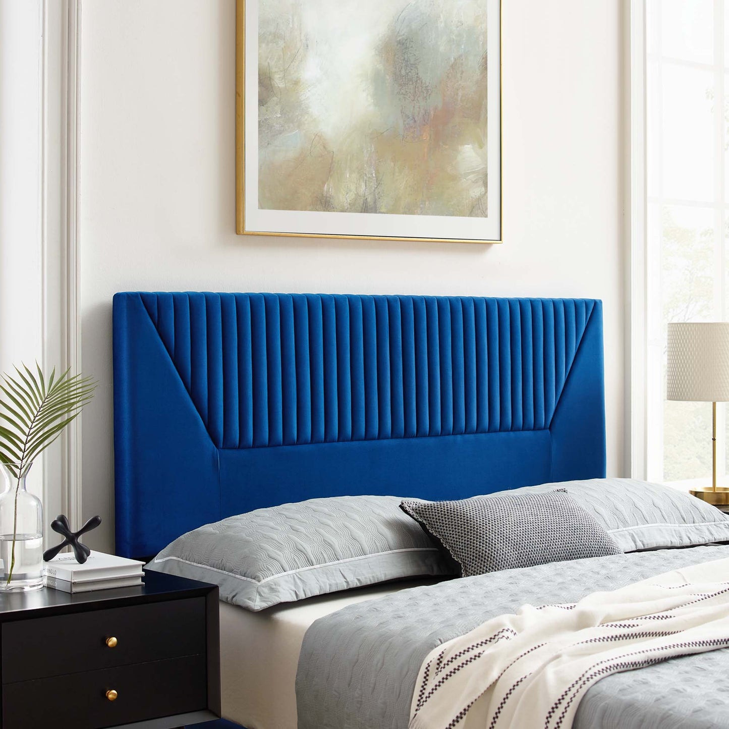 Navy velvet upholstered twin headboard with vertical channel tufting, black nightstand & gray bedding in a modern bedroom