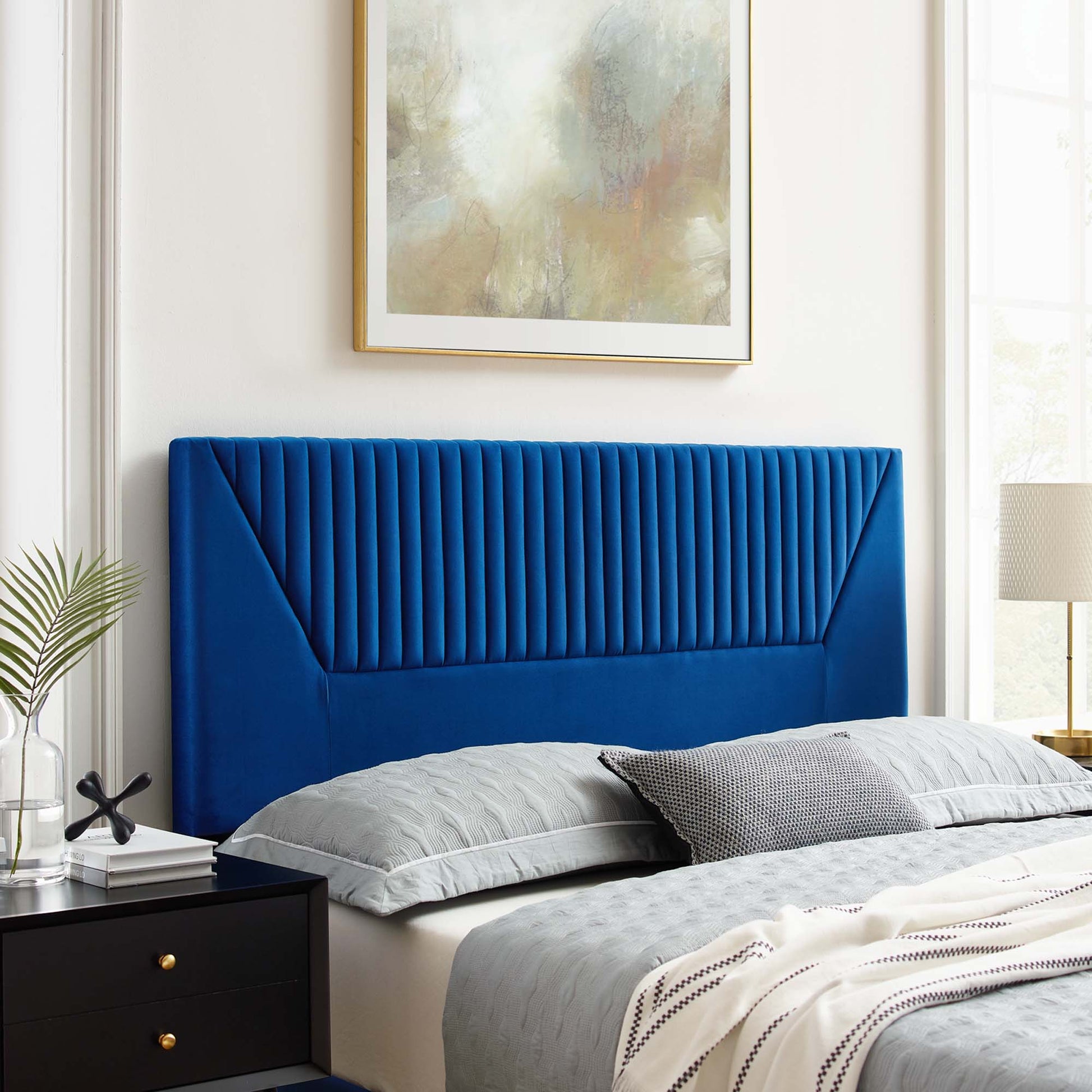 Navy velvet upholstered twin headboard with vertical channel tufting, black nightstand & gray bedding in a modern bedroom