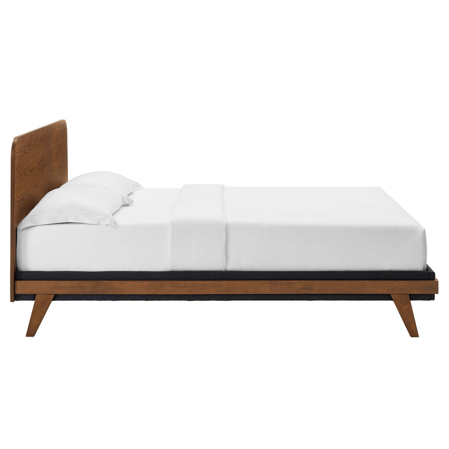 Walnut mid-century modern platform bed with angled legs and tall headboard, dressed in white linens.