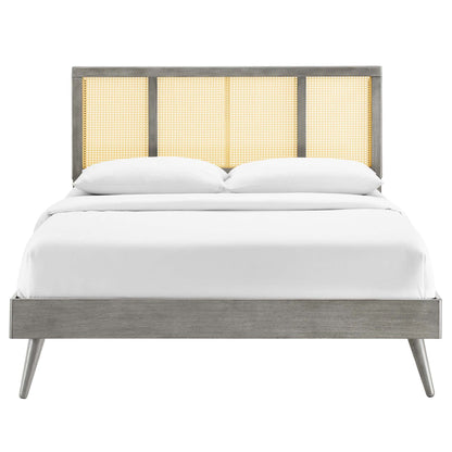 Mid-century modern grey wood full platform bed with caned headboard panels and splayed legs, white bedding.
