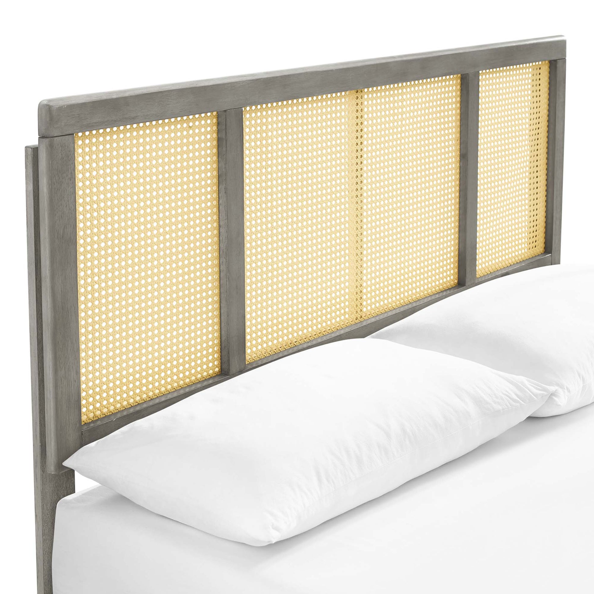 Graywashed wood full platform bed with a headboard of four woven cane panels and splayed legs; rustic coastal style, shown with white linens.