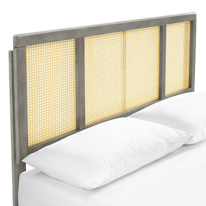 Graywashed wood full platform bed with a headboard of four woven cane panels and splayed legs; rustic coastal style, shown with white linens.