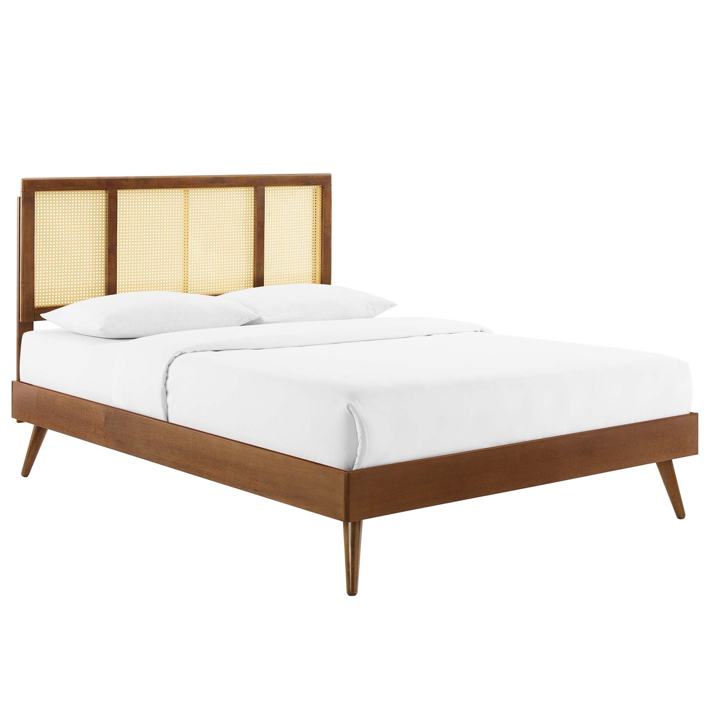 Walnut-finish full platform bed with caned headboard panels, white linens, and splayed legs.