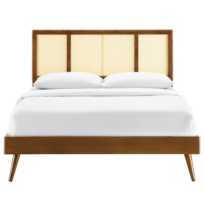 Walnut wood bed with cane-panel headboard & white bedding, full platform bed with mid-century modern style and splayed legs.