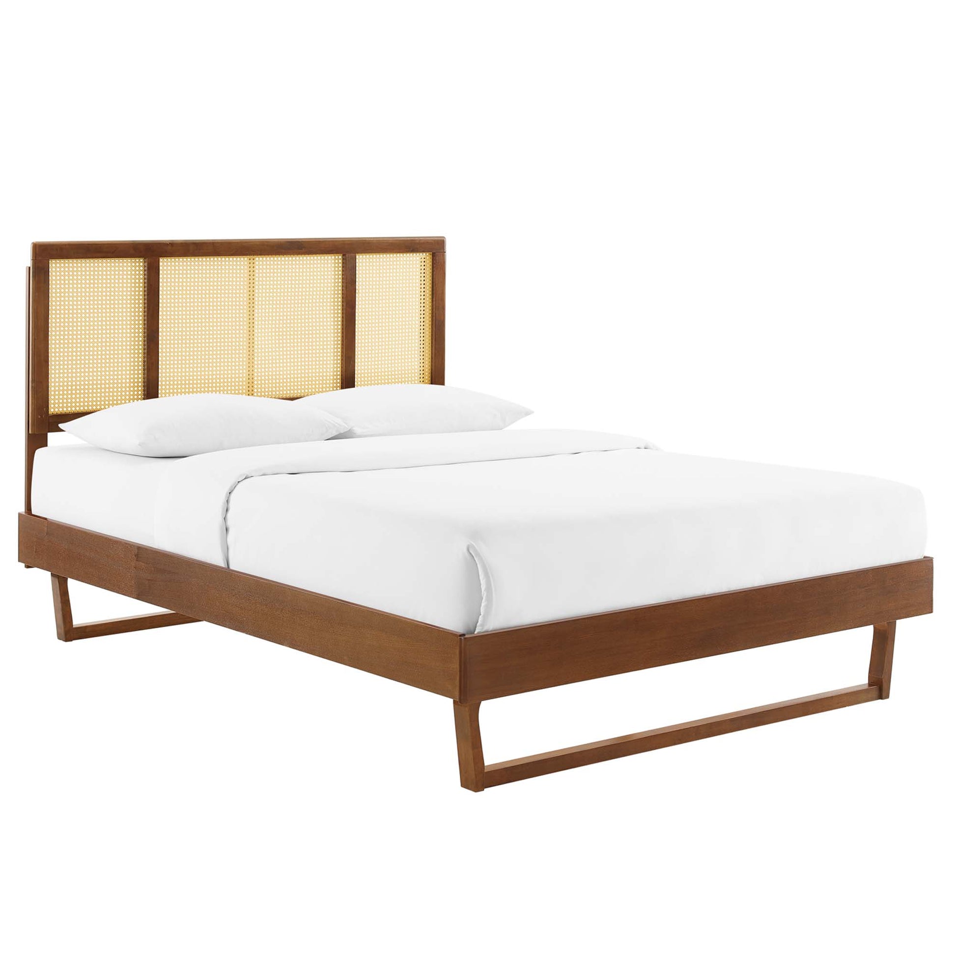 Walnut wooden platform bed with a caned headboard, white bedding and clean modern lines.
