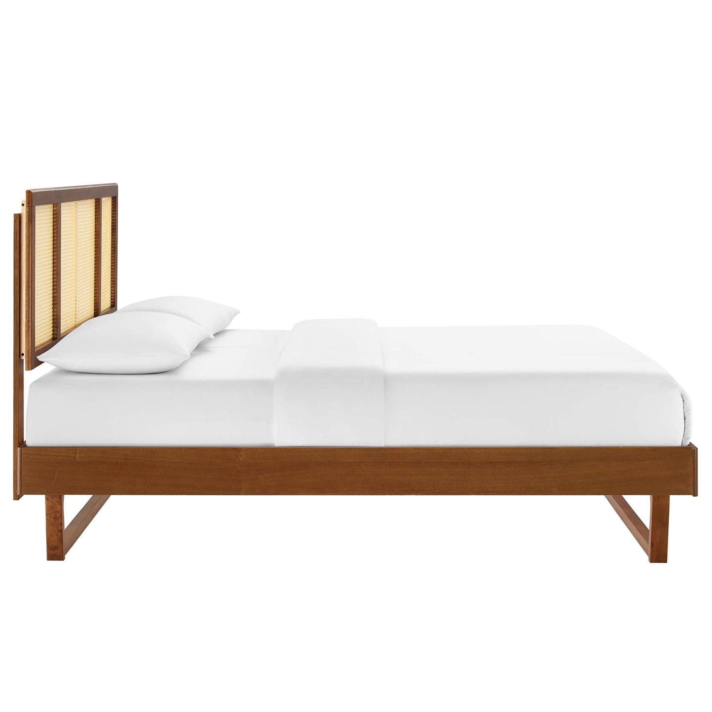 Walnut wood platform bed with cane-panel headboard, white bedding, low-profile design.