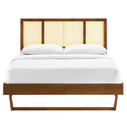 Walnut platform bed with cane headboard panels and crisp white bedding.
