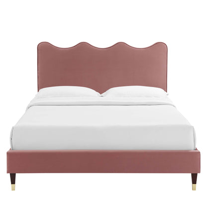 Dusty-rose velvet twin platform bed with a scalloped curved headboard and tapered brass-capped legs, white bedding.