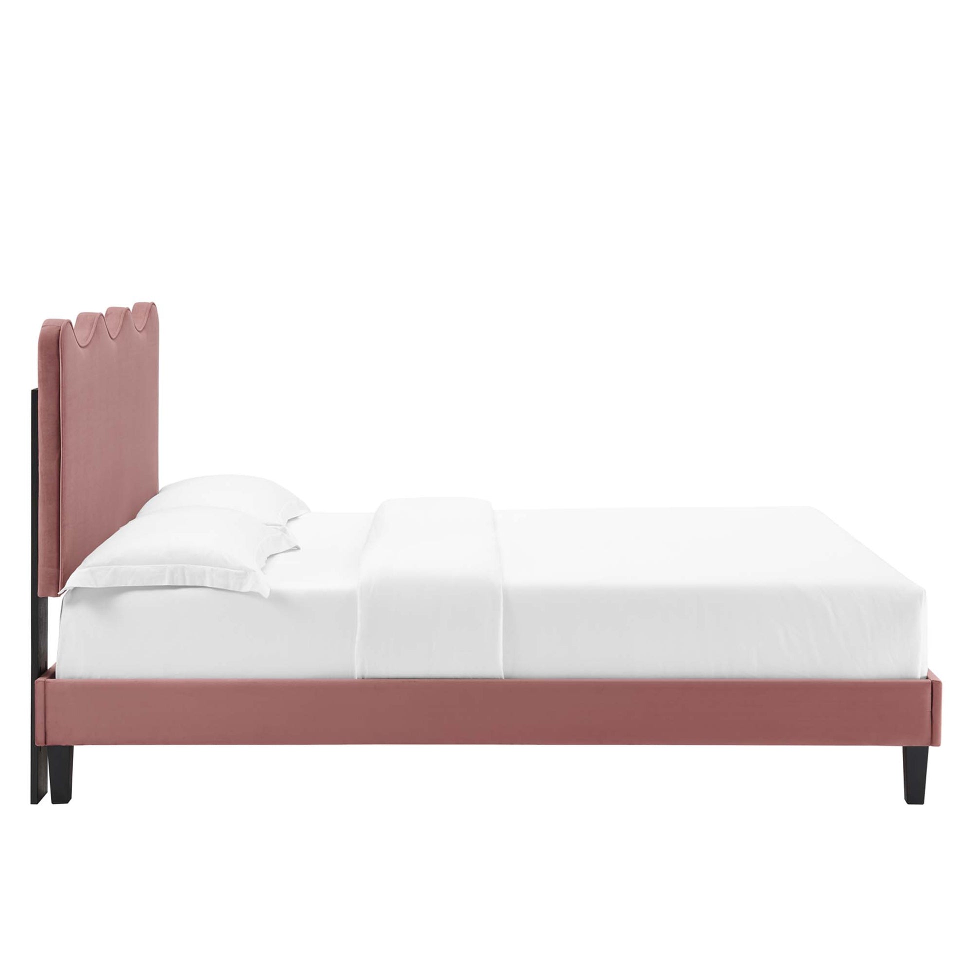 Dusty rose upholstered bed with tall scalloped headboard, low platform frame, black legs and white bedding.