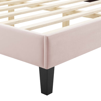 Blush pink upholstered platform bed frame with a black square leg and wooden slats.