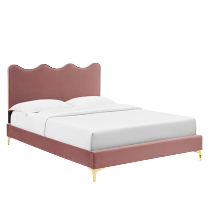 Red velvet upholstered full platform bed with a scalloped curved headboard, low platform frame, gold legs, and white bedding.