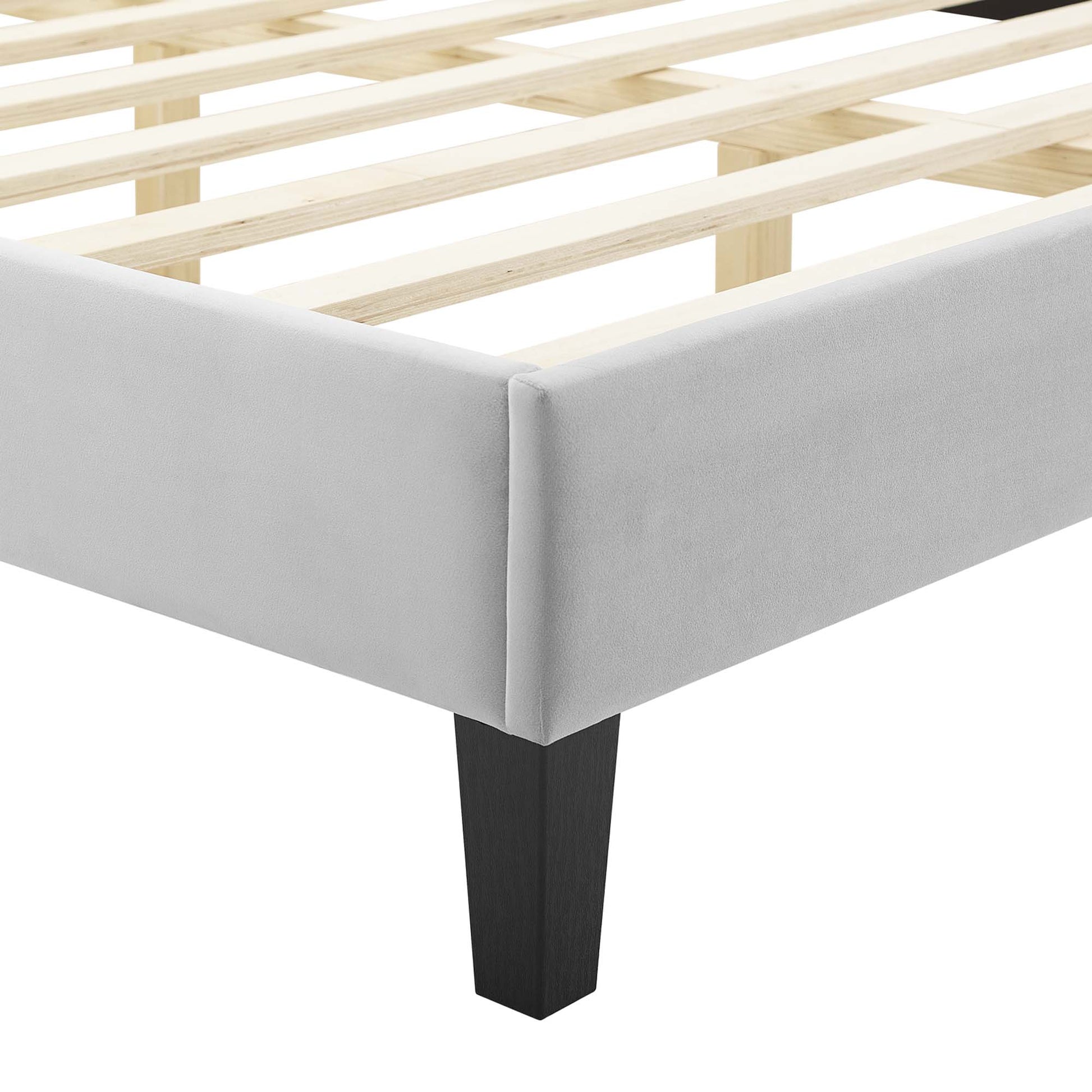 Gray upholstered platform bed frame with light wood slats and a black square leg, modern style.