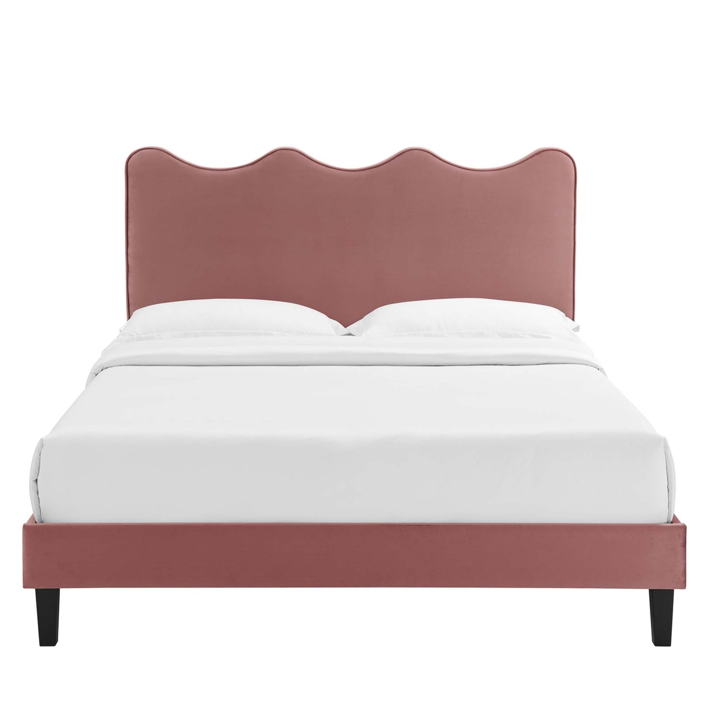 Dusty-rose upholstered bed with scalloped wave headboard, low platform frame, black tapered legs, and white bedding.