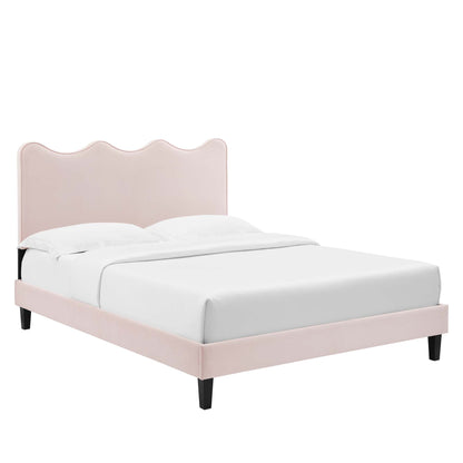 Red velvet queen platform bed with a scalloped headboard, white bedding, and tapered black legs in a modern glam style.