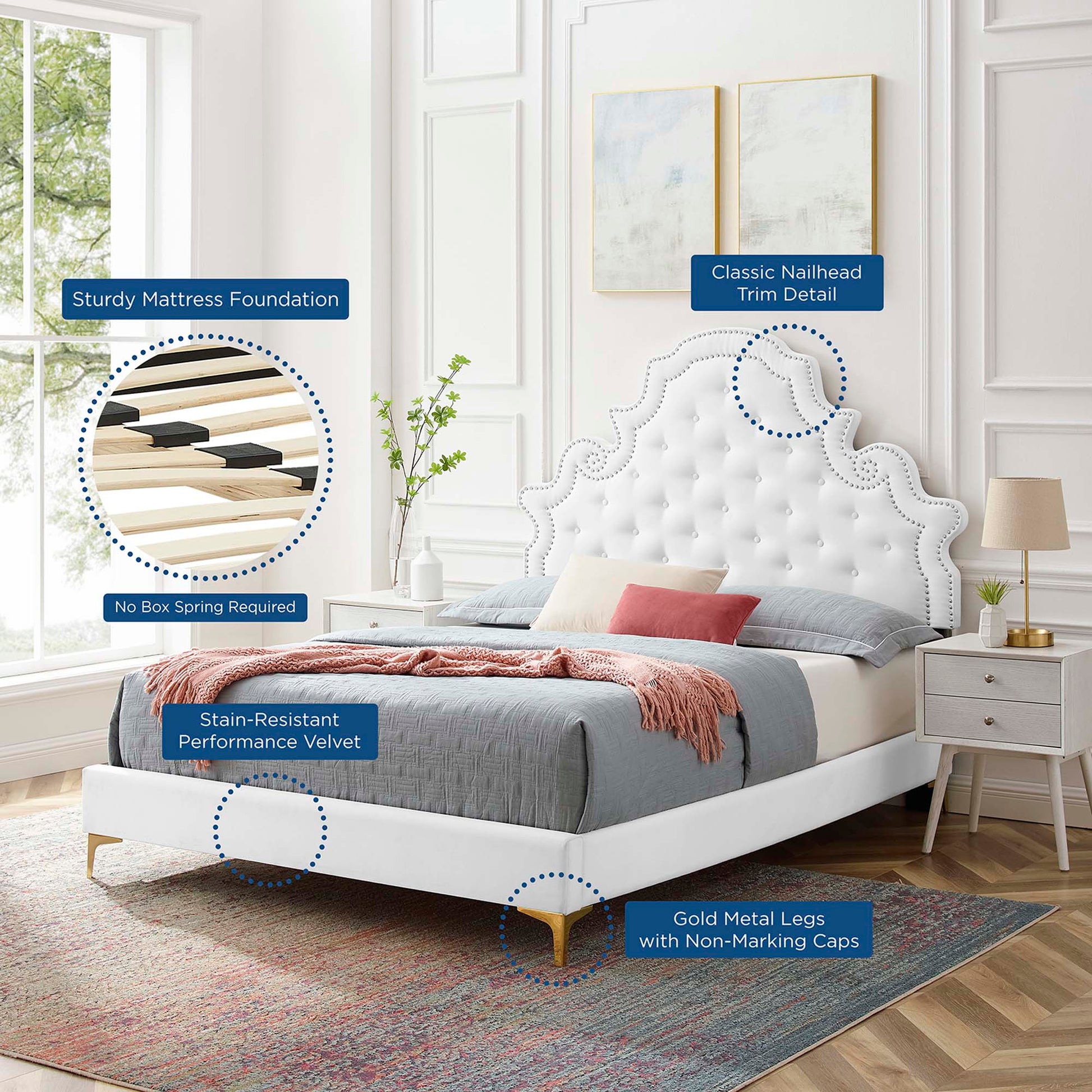 White tufted bed with scalloped headboard, gold legs, nailhead trim, velvet upholstery and grey bedding.