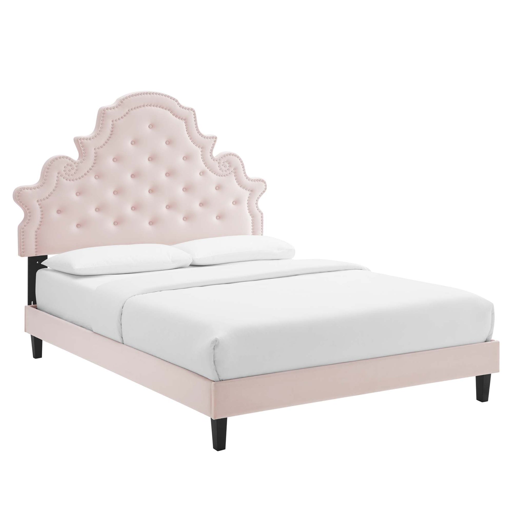 Red tufted headboard with an ornate scalloped crown on a red platform bed with black legs.
