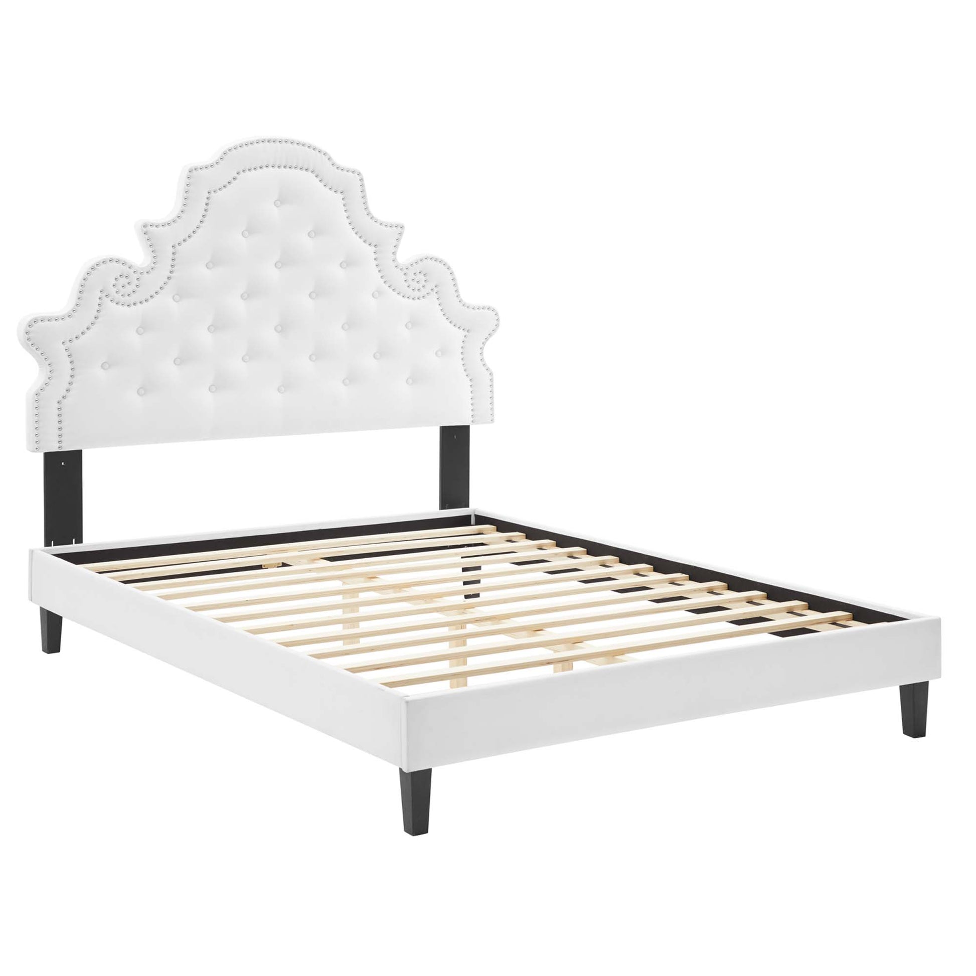 White upholstered queen platform bed with tufted, scalloped headboard and slatted base.