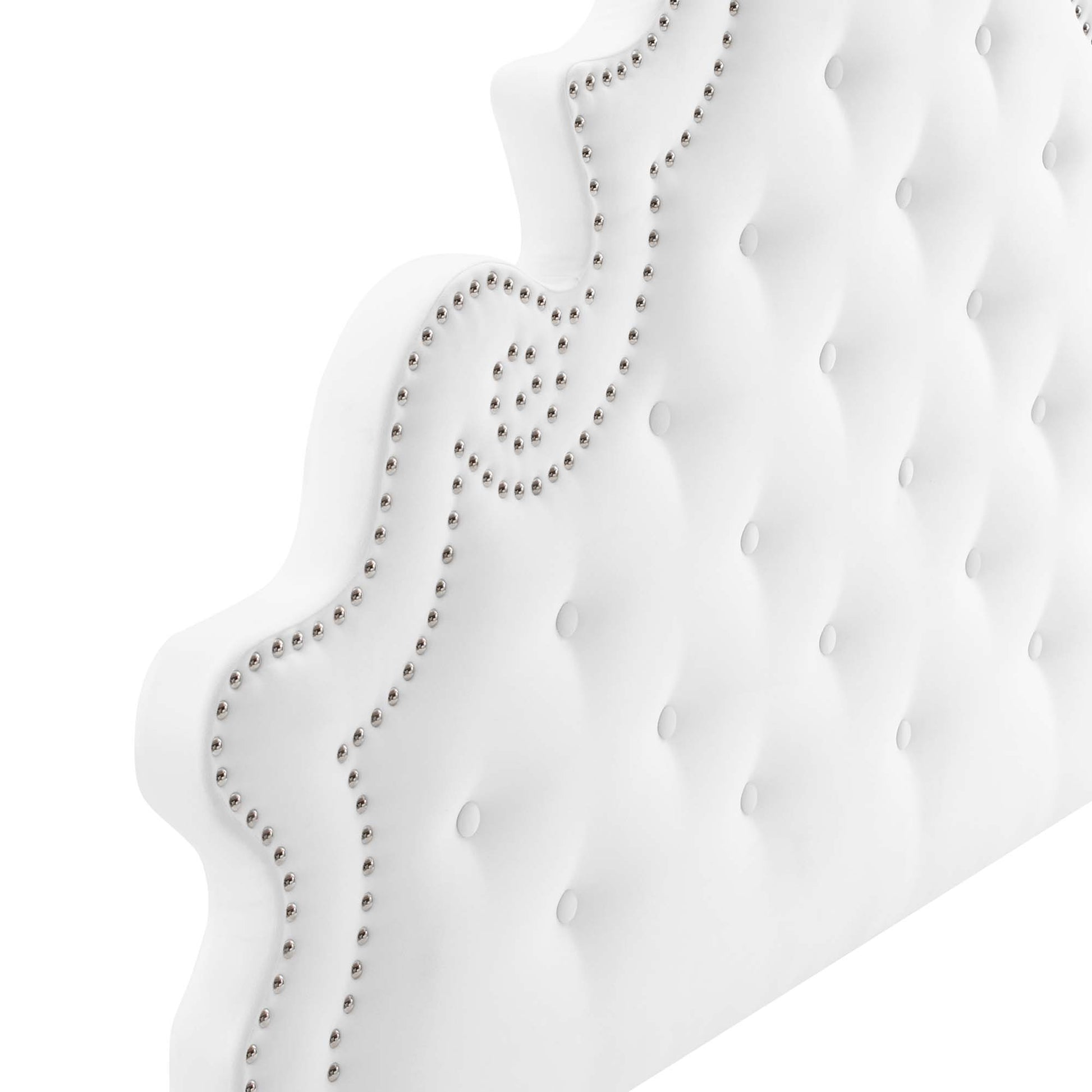 White tufted velvet queen platform bed with a curved scalloped headboard and silver nailhead trim.