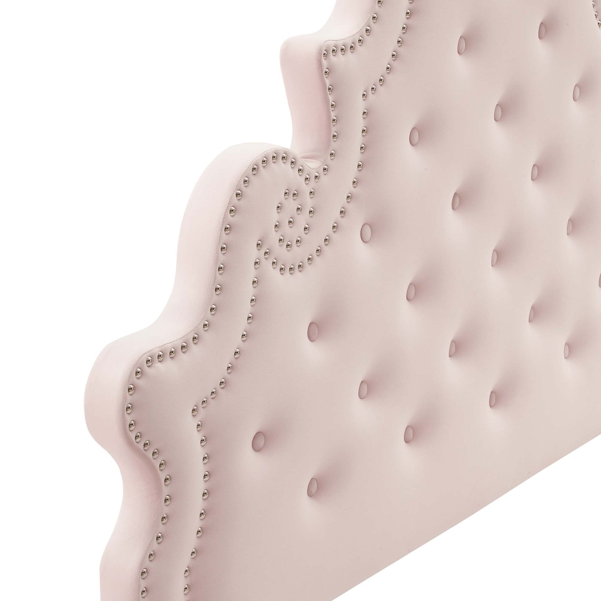 Pastel pink tufted velvet full platform bed with a scalloped-edged headboard and nailhead trim.