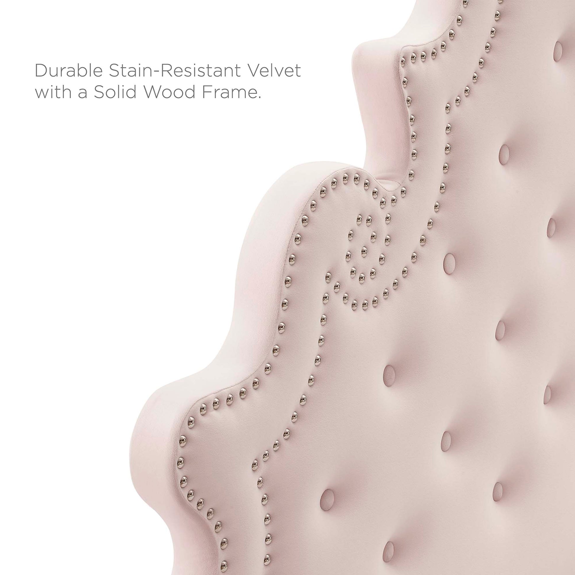 Close-up of pink velvet tufted headboard with nailhead trim and curved silhouette; solid wood platform bed frame.