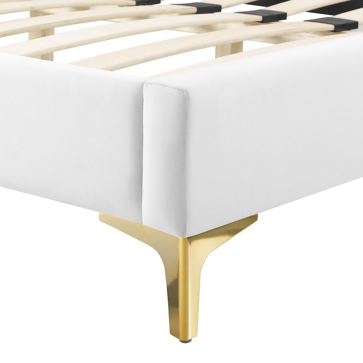 Corner of white upholstered bed frame with wooden slats and a gold metal leg.