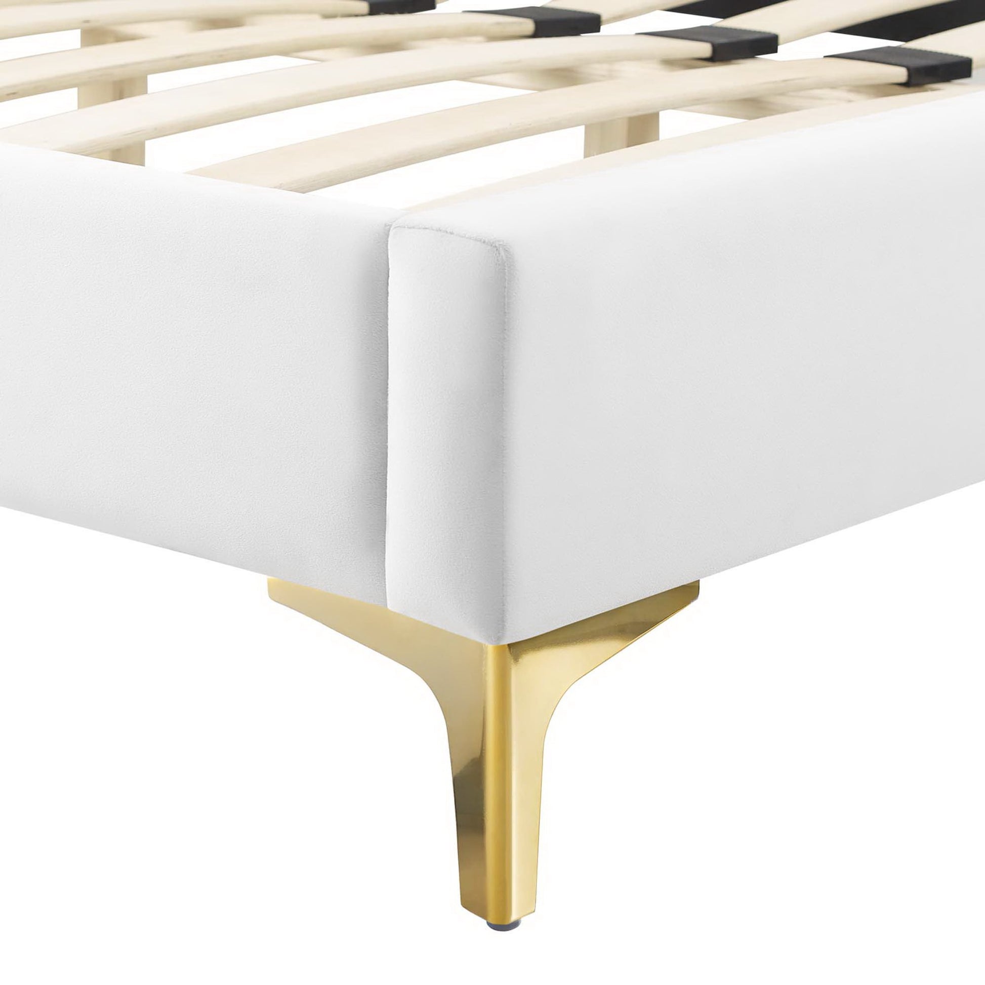 Corner of white upholstered bed frame with wooden slats and a gold metal leg.