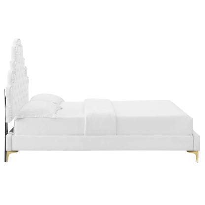 White velvet tufted full platform bed with a tall headboard, low platform frame, dressed in white linens.