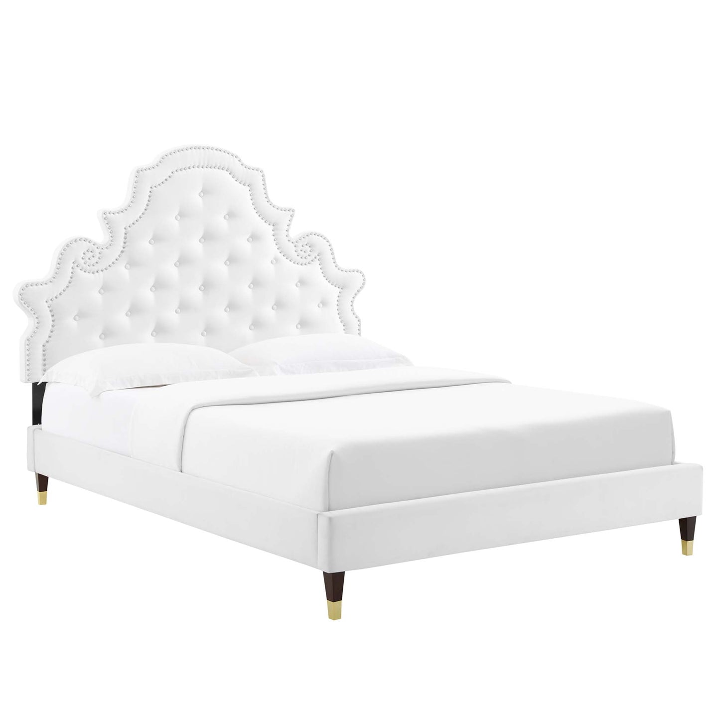 White upholstered platform bed with a scalloped, tufted headboard, nailhead trim, and gold-tipped legs.