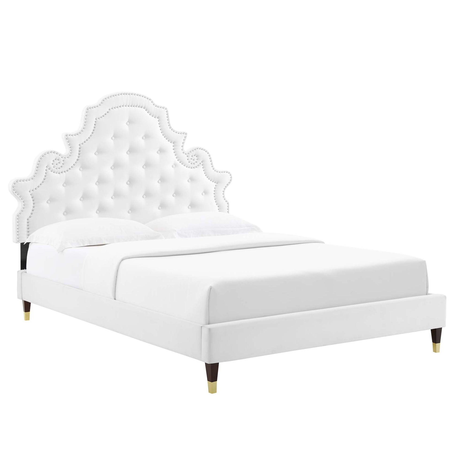 White upholstered platform bed with a scalloped, tufted headboard, nailhead trim, and gold-tipped legs.