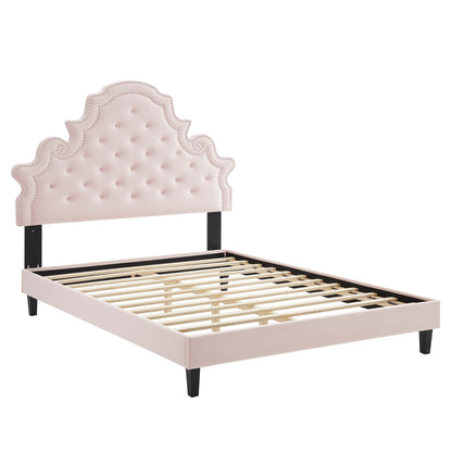 Pink tufted velvet full platform bed with ornate scalloped headboard, black posts, pale pink rails, and wooden slats.