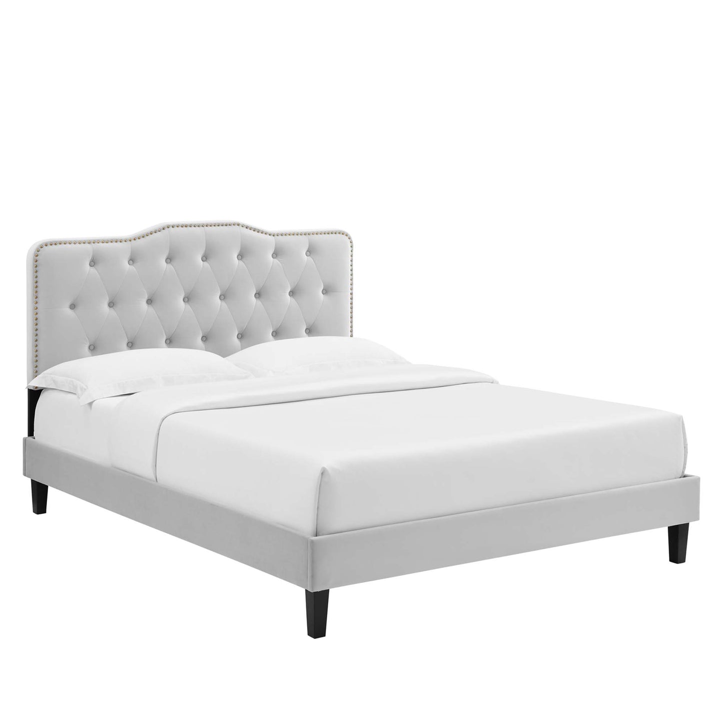 Gray upholstered twin platform bed with tufted headboard & nailhead trim, white bedding, dark legs