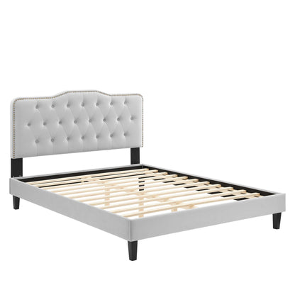 Light gray tufted upholstered bed frame with headboard, nailhead trim, slatted wood base and black legs.