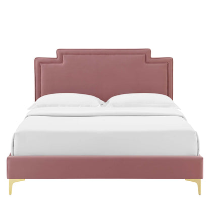 Dusty-rose velvet upholstered bed with stepped panel headboard, low footboard, & gold legs, dressed in white bedding.
